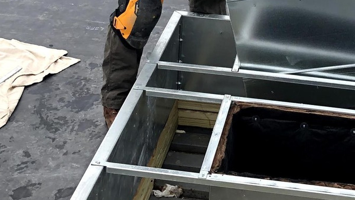Rooftop commercial HVAC ductwork and roof curb opening during installation work