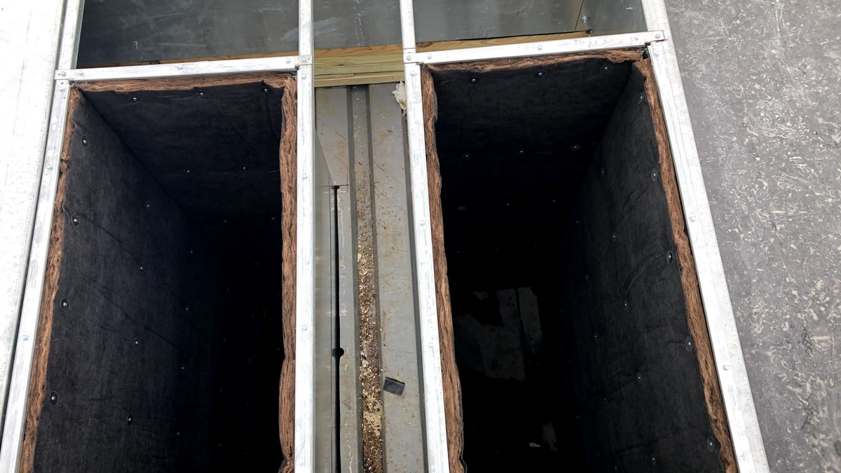 Commercial rooftop HVAC duct openings and insulated roof curb during installation.